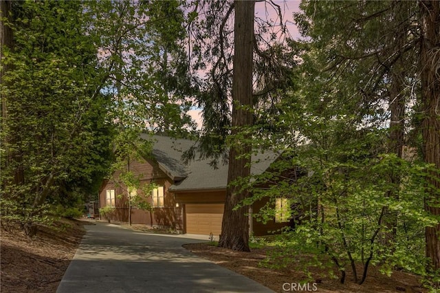 523 Dogwood Canyon Rd, Blue Jay, CA 92317 - obstructed view of property with driveway, an attached garage, and roof with shingles