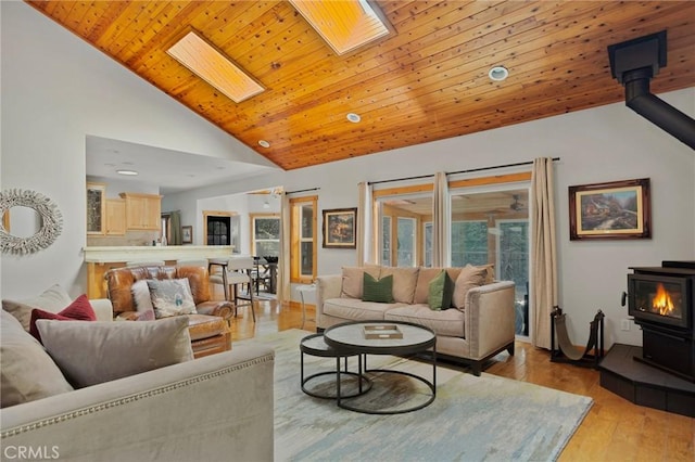 523 Dogwood Canyon Rd, Blue Jay, CA 92317 - living area featuring a wood stove, lofted ceiling, a skylight, light wood finished floors, and wood ceiling