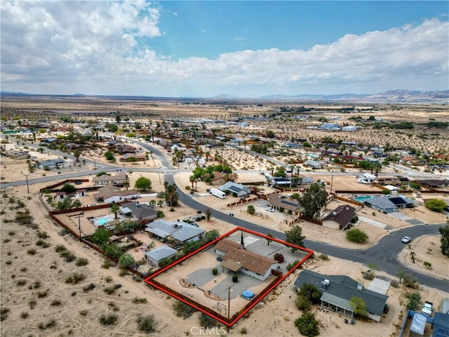 aerial view of residential area featuring property boundaries highlighted, mountains, and a desert landscape