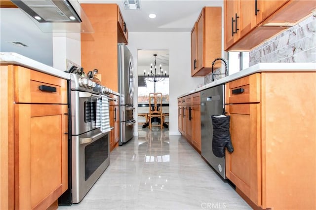 kitchen featuring stainless steel appliances, a chandelier, light marble finish floors, light countertops, and range hood
