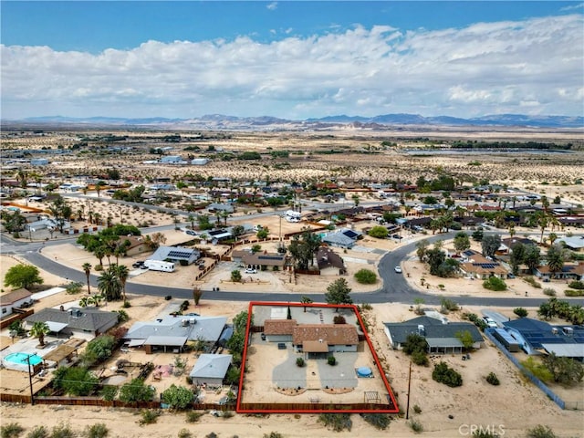 aerial perspective of suburban area with a mountain backdrop, property boundaries highlighted, and a desert landscape