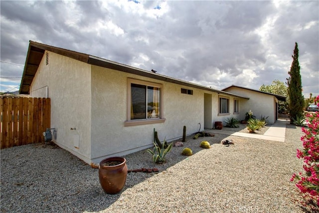 view of front of home with stucco siding and fence