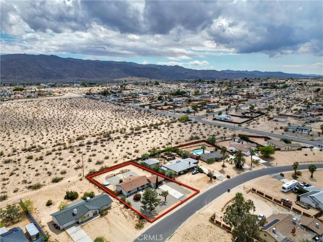 aerial view of property's location featuring property parcel outlined, a mountainous background, and a desert landscape