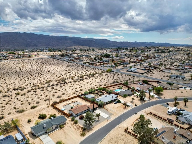 aerial perspective of suburban area featuring a mountain backdrop and a desert landscape