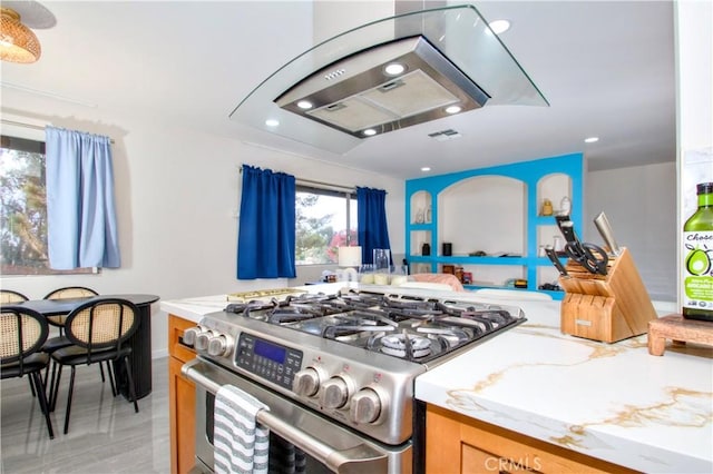 kitchen featuring stainless steel gas range, recessed lighting, and light stone countertops