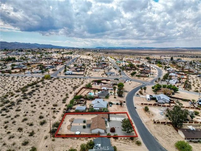 aerial view of residential area with property parcel outlined and a mountain backdrop