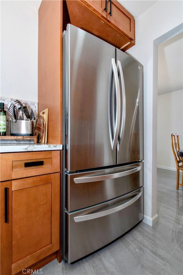 detailed view of freestanding refrigerator and baseboards