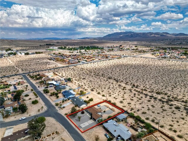 aerial view of property's location featuring a mountainous background, property boundaries highlighted, and a desert landscape