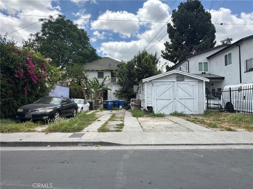 view of front of home featuring fence, a storage unit, and an outdoor structure