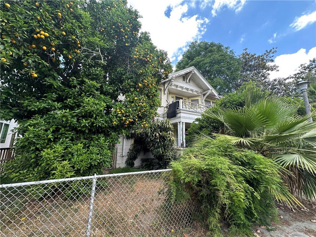 view of property exterior featuring a balcony and fence