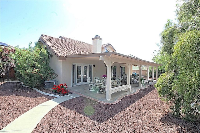 6102 Cabriolet Ct, Quartz Hill, CA 93536 - back of house with french doors, stucco siding, a chimney, a patio, and central AC