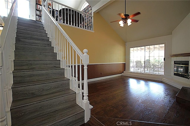 6102 Cabriolet Ct, Quartz Hill, CA 93536 - stairs with a ceiling fan, wood finished floors, high vaulted ceiling, a tile fireplace, and baseboards