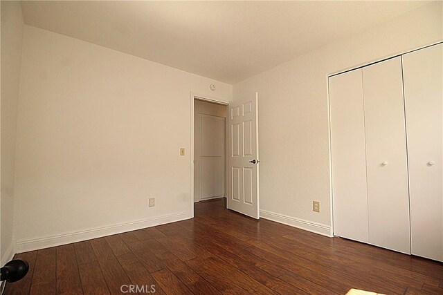 6102 Cabriolet Ct, Quartz Hill, CA 93536 - unfurnished bedroom with dark wood-type flooring, baseboards, and a closet