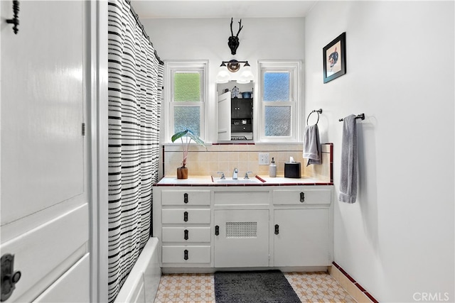 13611 Walnut St, Whittier, CA 90602 - full bath featuring vanity, shower / bath combo with shower curtain, backsplash, and tile patterned floors