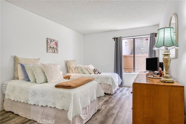 15155 Sherman Way Unit 14, Van Nuys, CA 91405 - bedroom with wood finished floors and a textured ceiling