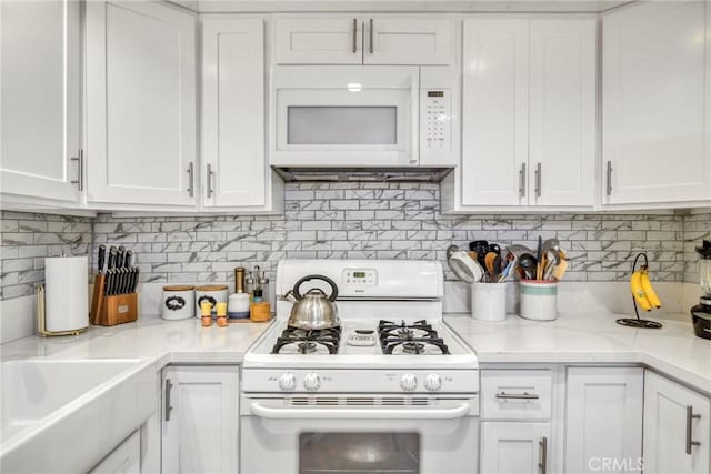 15155 Sherman Way Unit 14, Van Nuys, CA 91405 - kitchen with white appliances, white cabinets, light countertops, and decorative backsplash