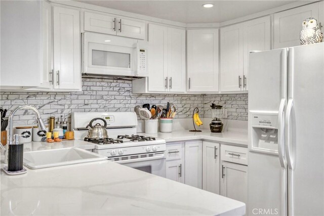 15155 Sherman Way Unit 14, Van Nuys, CA 91405 - kitchen featuring white appliances, white cabinetry, tasteful backsplash, light stone countertops, and recessed lighting