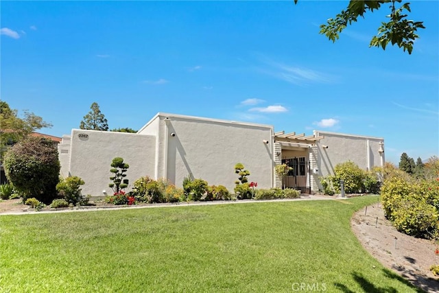 2262 Via Puerta Unit A, Laguna Woods, CA 92637 - view of front facade featuring stucco siding and a front yard
