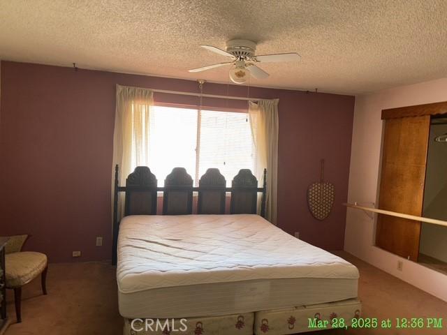 17216 Cedar Way, Clearlake Oaks, CA 95423 - bedroom with light carpet, a textured ceiling, and a ceiling fan