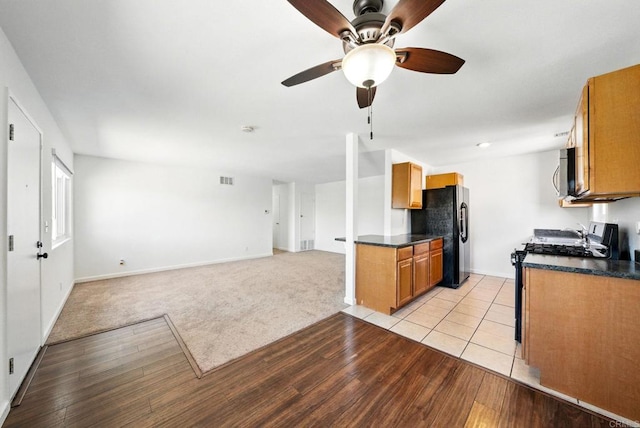 1316 W San Ysidro Blvd Unit D, San Ysidro, CA 92173 - kitchen with gas range, stainless steel microwave, freestanding refrigerator, and dark countertops