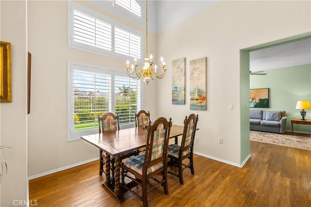 27567 Courtview Dr, Valencia, CA 91354 - dining area with wood finished floors, a chandelier, baseboards, and a towering ceiling