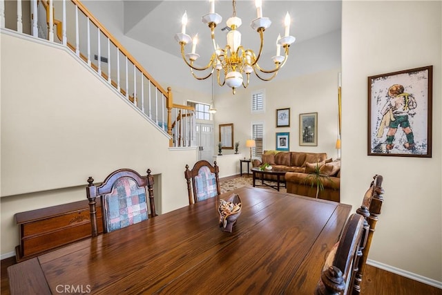 27567 Courtview Dr, Valencia, CA 91354 - dining space with a chandelier, baseboards, stairs, wood finished floors, and a towering ceiling