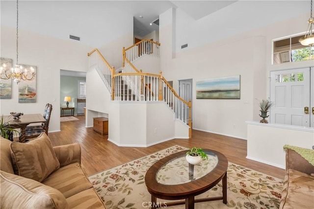 27567 Courtview Dr, Valencia, CA 91354 - living room featuring stairway, a chandelier, wood finished floors, a high ceiling, and baseboards