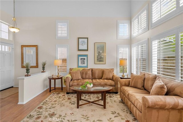 27567 Courtview Dr, Valencia, CA 91354 - living room with a towering ceiling, healthy amount of natural light, light wood finished floors, and baseboards