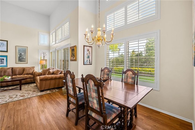 27567 Courtview Dr, Valencia, CA 91354 - dining space featuring a chandelier, a towering ceiling, wood finished floors, and baseboards