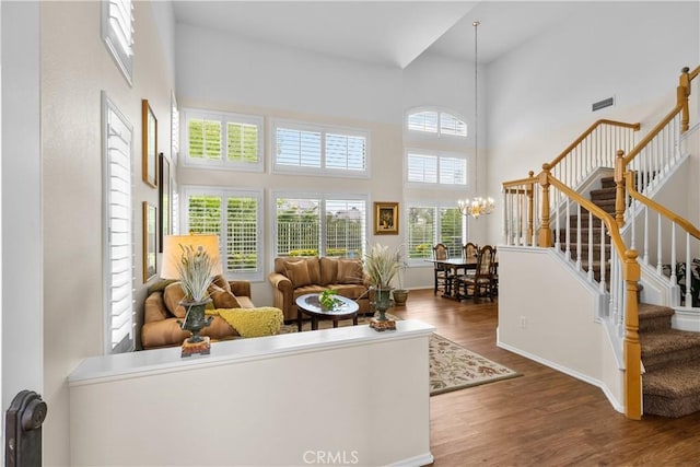 27567 Courtview Dr, Valencia, CA 91354 - living area featuring stairs, wood finished floors, a towering ceiling, a chandelier, and baseboards