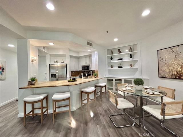 235 Main St Unit 118, Venice, CA 90291 - kitchen featuring appliances with stainless steel finishes, wood finished floors, recessed lighting, a peninsula, and a breakfast bar