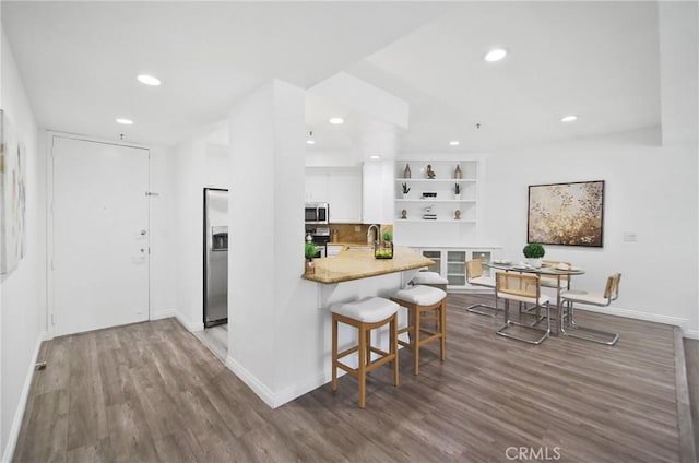 235 Main St Unit 118, Venice, CA 90291 - kitchen featuring stainless steel appliances, open shelves, recessed lighting, wood finished floors, and white cabinetry