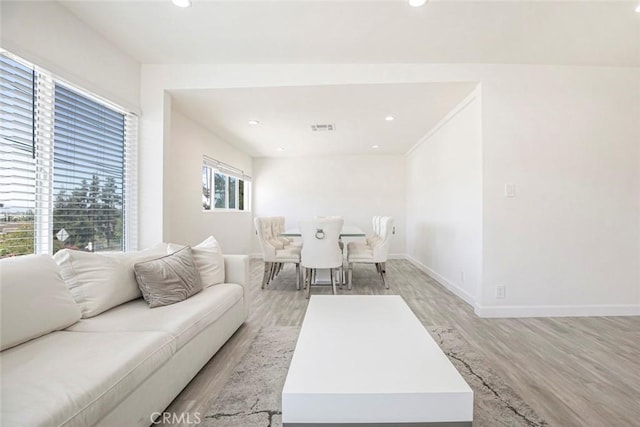 living area with light wood-style flooring, baseboards, and recessed lighting