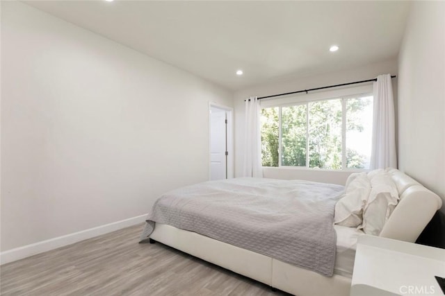 bedroom with recessed lighting, baseboards, and wood finished floors