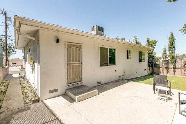 back of property with a patio area, crawl space, stucco siding, and fence