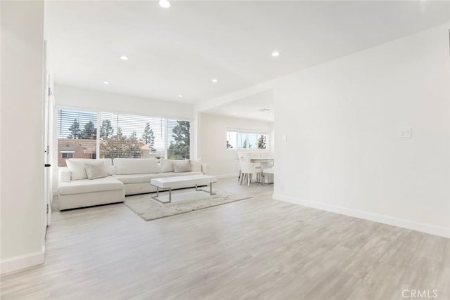 living area featuring recessed lighting, light wood-style floors, and baseboards