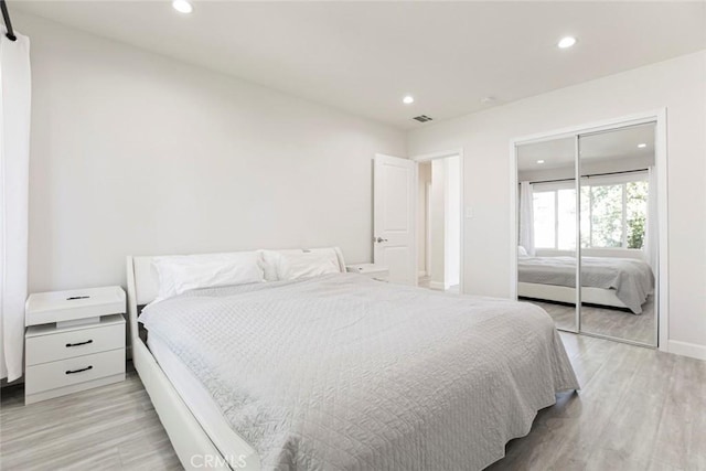 bedroom featuring recessed lighting, light wood-style floors, a closet, and baseboards