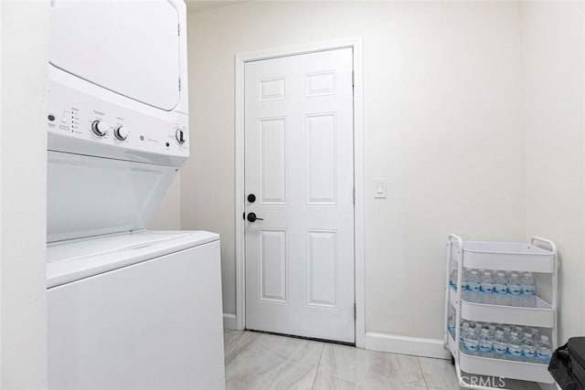 washroom featuring estacked washer and dryer and baseboards