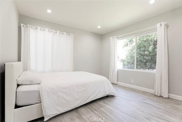 bedroom featuring baseboards, recessed lighting, and wood finished floors