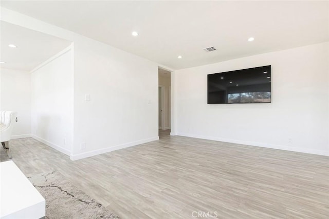 unfurnished living room with wood finished floors, baseboards, and recessed lighting