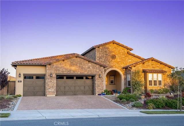 851 Trail View Pl, Nipomo, CA 93444 - mediterranean / spanish-style house with a garage, a tile roof, decorative driveway, stucco siding, and stone siding