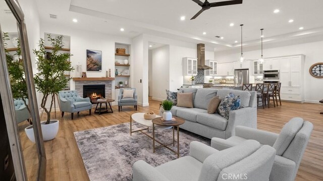 851 Trail View Pl, Nipomo, CA 93444 - living room with a ceiling fan, recessed lighting, a fireplace, light wood finished floors, and a raised ceiling