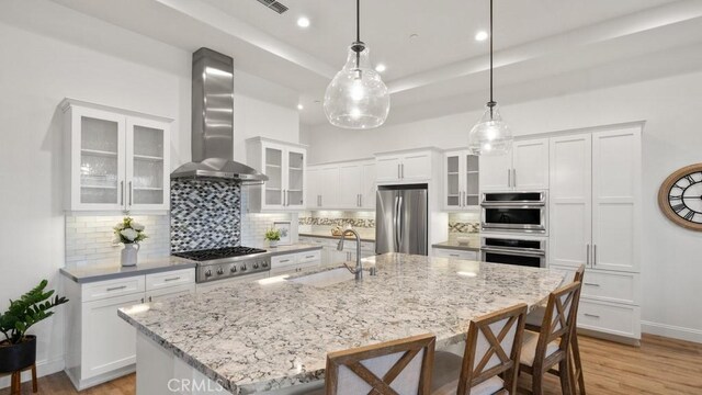 851 Trail View Pl, Nipomo, CA 93444 - kitchen with appliances with stainless steel finishes, wall chimney exhaust hood, a kitchen island with sink, decorative backsplash, and recessed lighting
