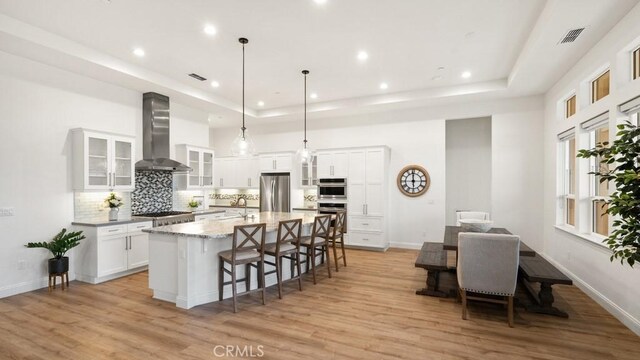 851 Trail View Pl, Nipomo, CA 93444 - kitchen with appliances with stainless steel finishes, wall chimney exhaust hood, tasteful backsplash, light wood-style floors, and recessed lighting