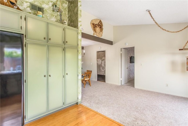2605 La Praix St, Highland, CA 92346 - kitchen featuring green cabinetry, stainless steel refrigerator, lofted ceiling, and light carpet