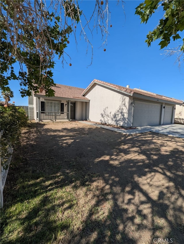 10736 Dove Ct, Adelanto, CA 92301 - ranch-style house with stucco siding, a garage, a porch, and concrete driveway