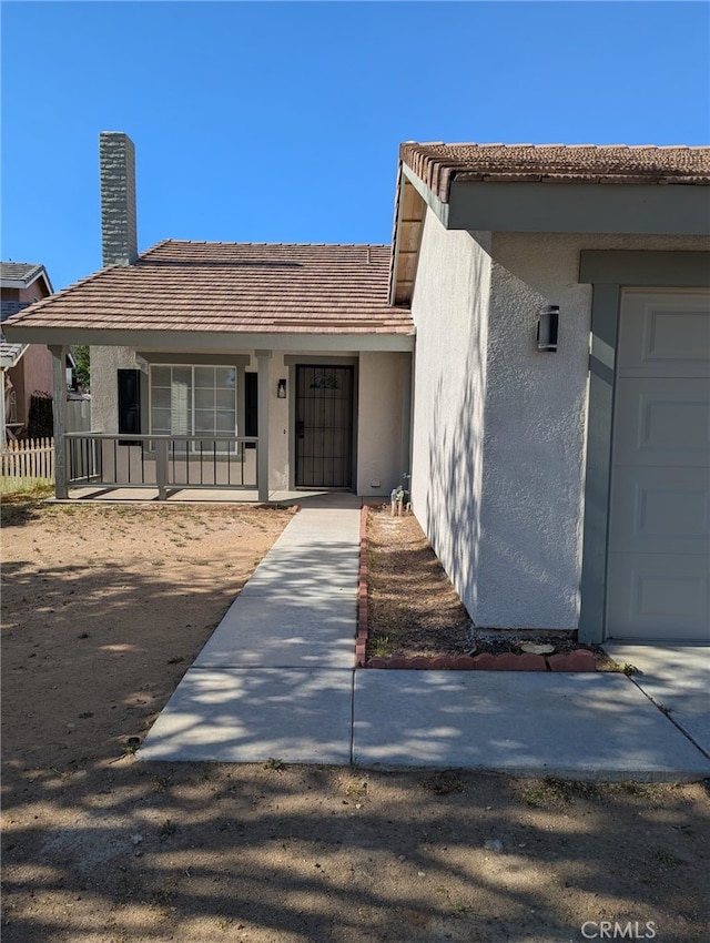 10736 Dove Ct, Adelanto, CA 92301 - property entrance with stucco siding, a porch, and fence