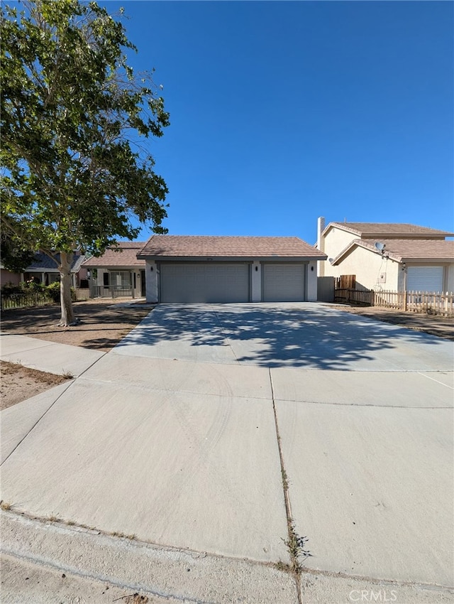 10736 Dove Ct, Adelanto, CA 92301 - ranch-style house featuring concrete driveway, fence, and an attached garage