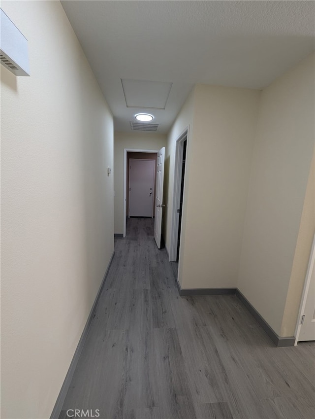 10736 Dove Ct, Adelanto, CA 92301 - hallway with wood finished floors, baseboards, and attic access