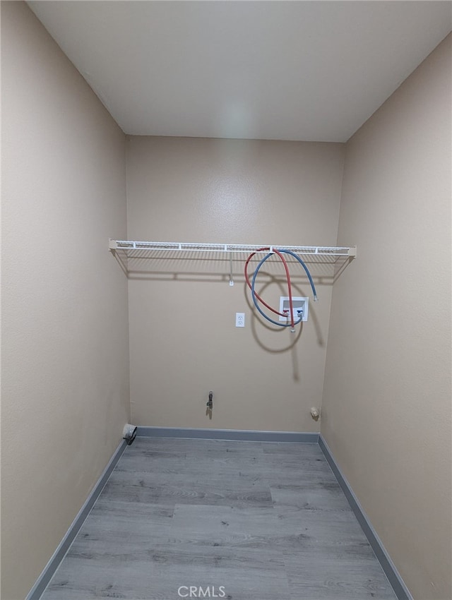 10736 Dove Ct, Adelanto, CA 92301 - laundry room featuring washer hookup, wood finished floors, and baseboards